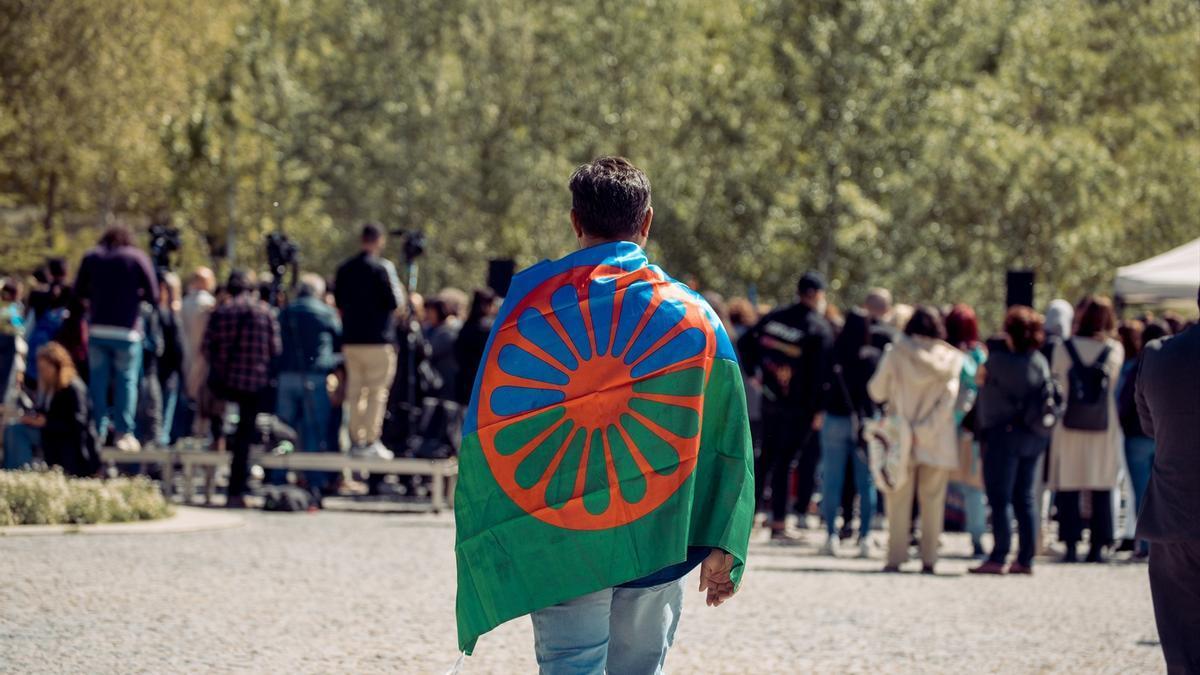 Una persona con una bandera gitana a su espalda durante un acto conmemorativo del Día Internacional del Pueblo Gitano.