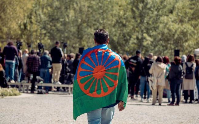 Una persona con una bandera gitana a su espalda durante un acto conmemorativo del Día Internacional del Pueblo Gitano.