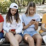 Cuatro adolescentes, utilizando sus teléfonos móviles | Freepik