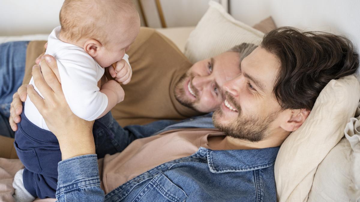 Dos hombres contemplan con ternura a su hijo.