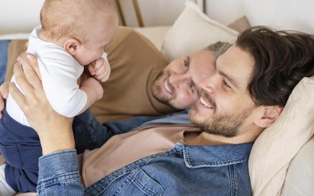 Dos hombres contemplan con ternura a su hijo.