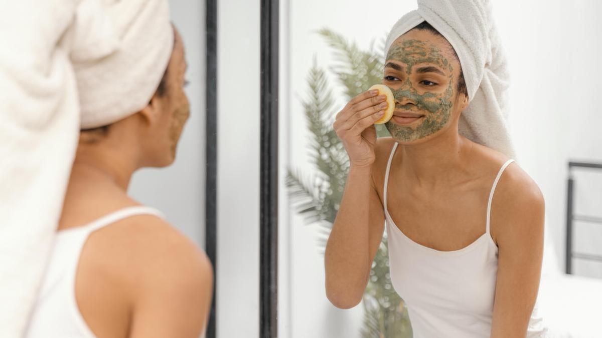 Chica realiza una exfoliación facial en casa.