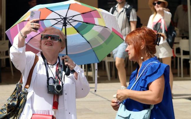 Dos mujeres se protegen del sol con una sombrilla en Málaga. / EP Dos mujeres se protegen del sol con una sombrilla en Málaga.