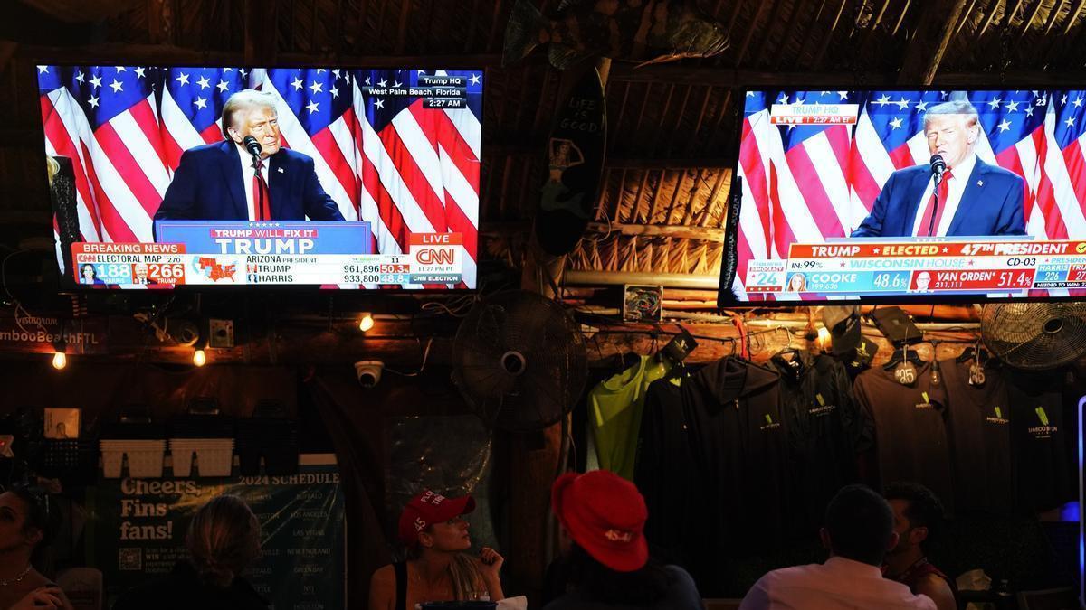 Seguidores de Donald Trump siguen el discurso del republicano durante la noche electoral.