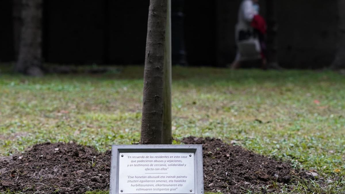 La placa, en memoria de los menores abusados, a los pies de la encina en los jardines de La Misericordia.