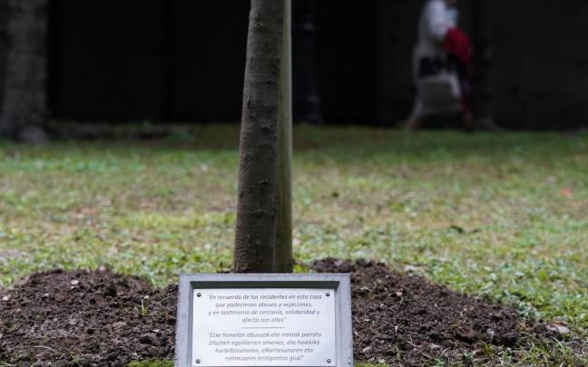 La placa, en memoria de los menores abusados, a los pies de la encina en los jardines de La Misericordia.