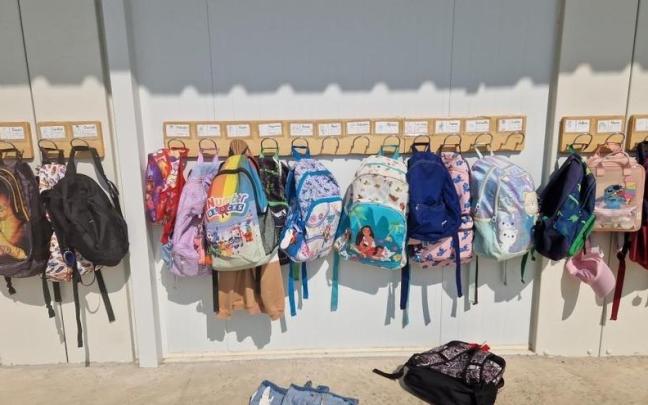 Un perchero con mochilas en un centro educativo.