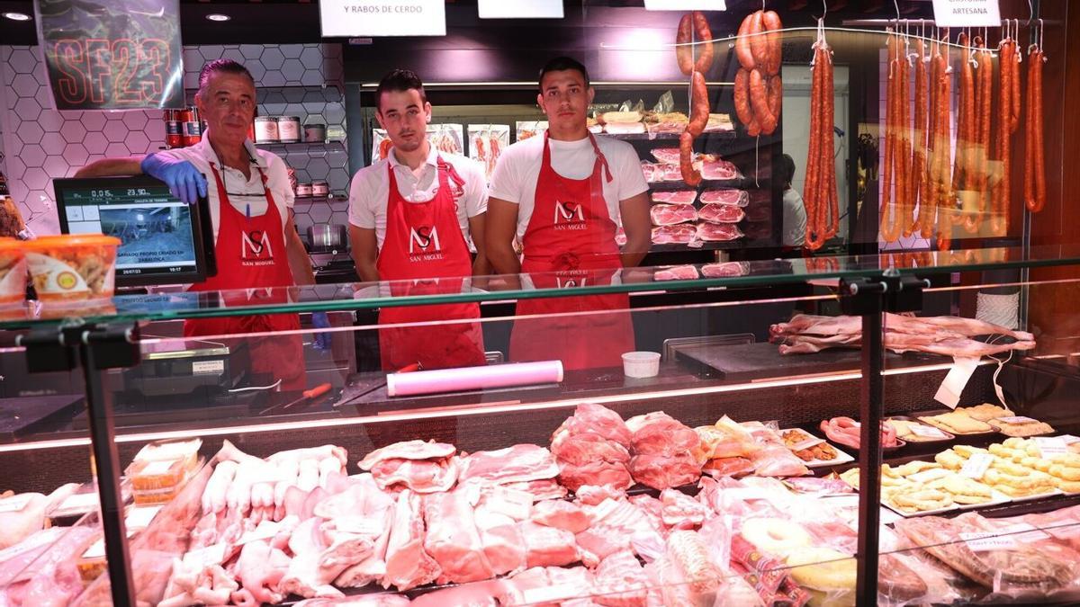 De izquierda a derecha, Juan Andrés y sus hijos Pablo y Andrés, posan tras el mostrador de la carnicería San Miguel del Mercado del Ensanche.