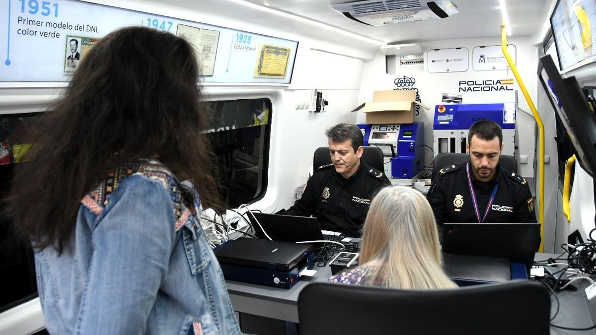 Dos miembros de la Polícia Nacional tramitan la documentación en una unidad móvil del área de documentación.