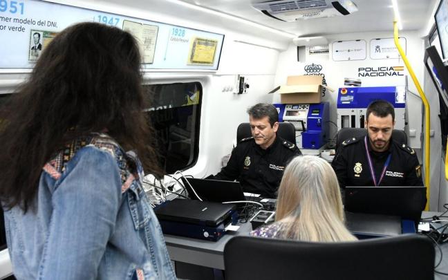 Dos miembros de la Polícia Nacional tramitan la documentación en una unidad móvil del área de documentación.