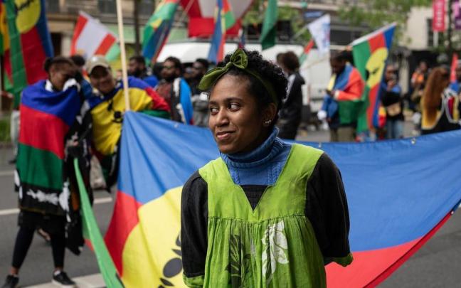 Una joven lleva una bandera de Nueva Caledonia durante una protesta en París el pasado año
