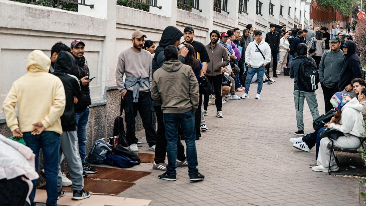 Varias personas hacen cola para conseguir el certificado de vulnerabilidad en una Oficina de Asistencia en Madrid.