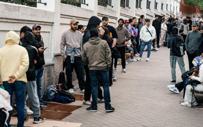 Varias personas hacen cola para conseguir el certificado de vulnerabilidad en una Oficina de Asistencia en Madrid.