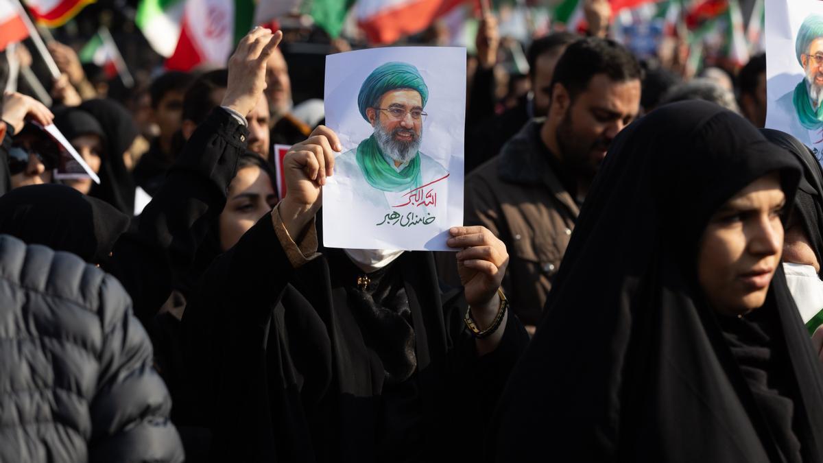 Una manifestante muestra una imagen del nuevo líder supremo de Irán, Mojtaba Jamenei.