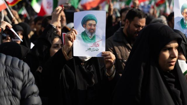 Una manifestante muestra una imagen del nuevo líder supremo de Irán, Mojtaba Jamenei.