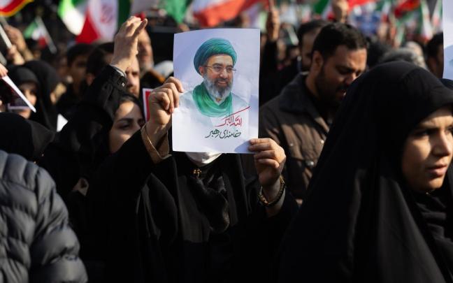 Una manifestante muestra una imagen del nuevo líder supremo de Irán, Mojtaba Jamenei.