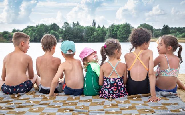 Niños y niñas disfrutando de una tarde en un lago.