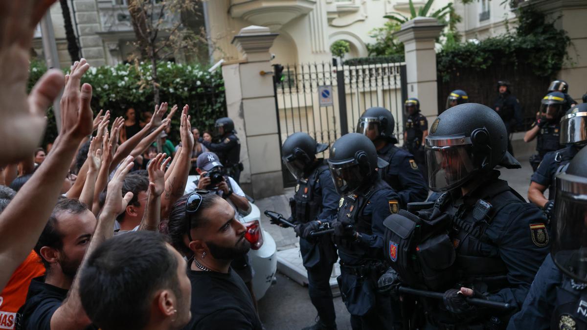 Decenas de personas frente a varios agentes de Policía Nacional durante una concentración frente al ático de Chamberí.