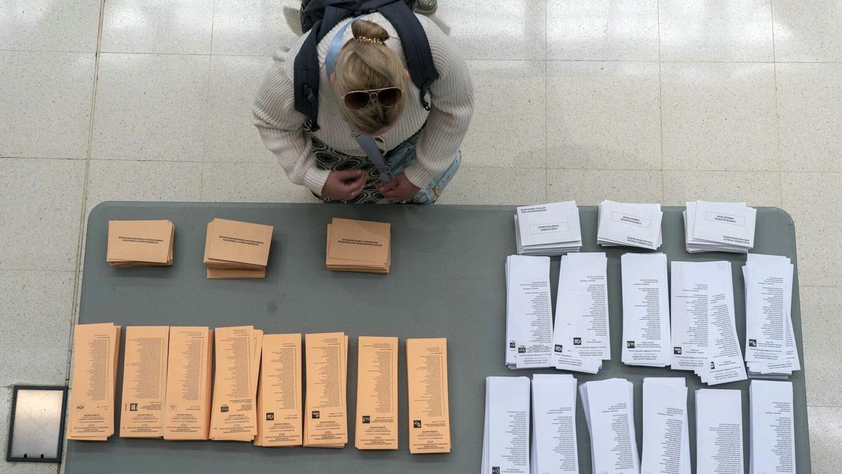 Mesa con papeletas de diferentes partidos en las elecciones municipales y forales del 28 de mayo.