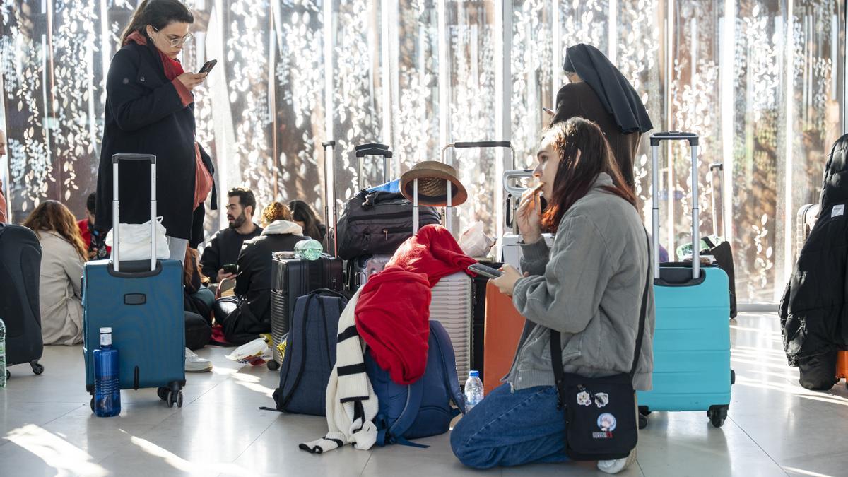 Varias personas esperan con sus maletas en la Estación de Cuenca-Fernando Zóbel durante el apagón.
