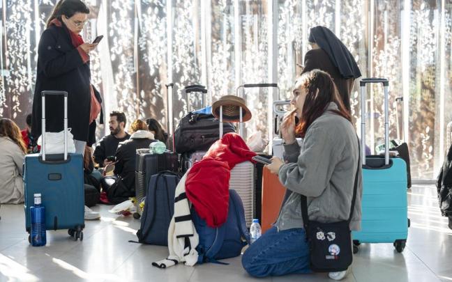 Varias personas esperan con sus maletas en la Estación de Cuenca-Fernando Zóbel durante el apagón.