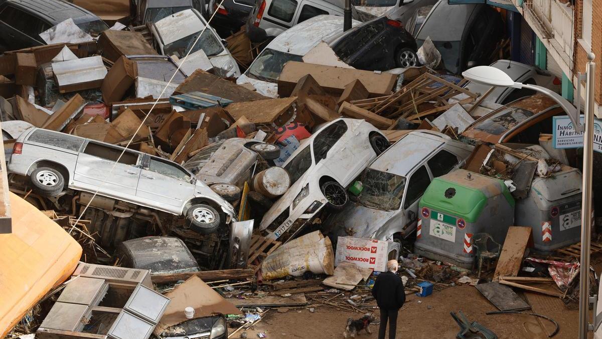 Vehículos amontonados en una calle tras las intensas lluvias en Picaña, Valencia.