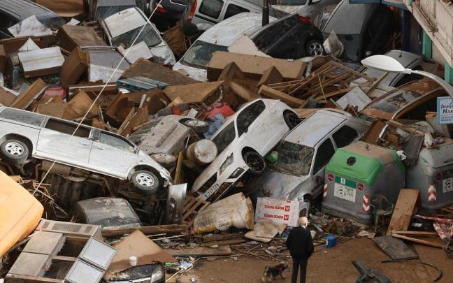 Vehículos amontonados en una calle tras las intensas lluvias en Picaña, Valencia.