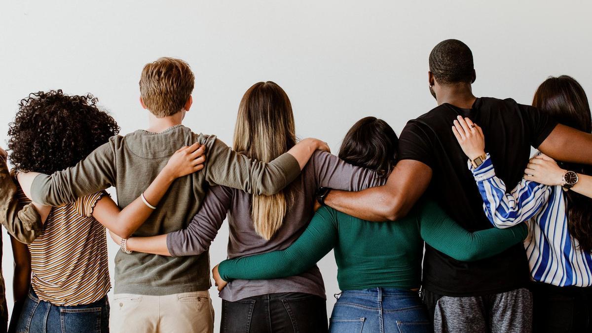 Hombres y mujeres jóvenes de espaldas se funden en un abrazo.