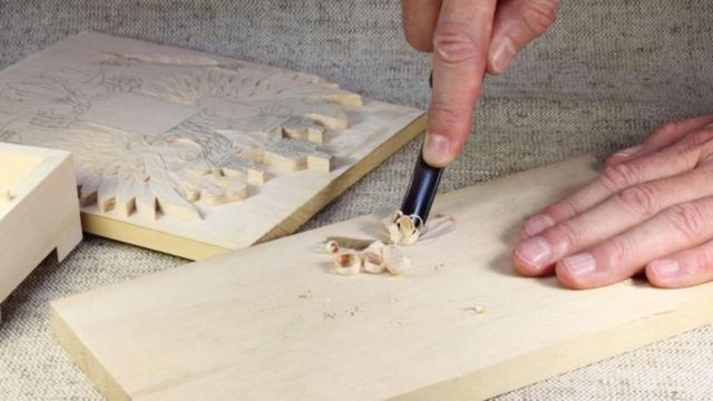 Una persona tallando en la madera.