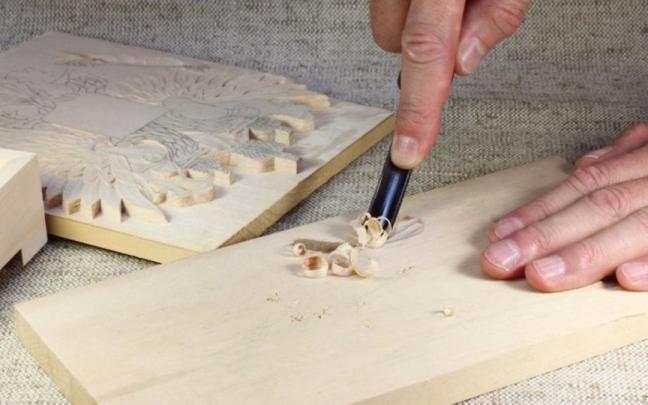 Una persona tallando en la madera.