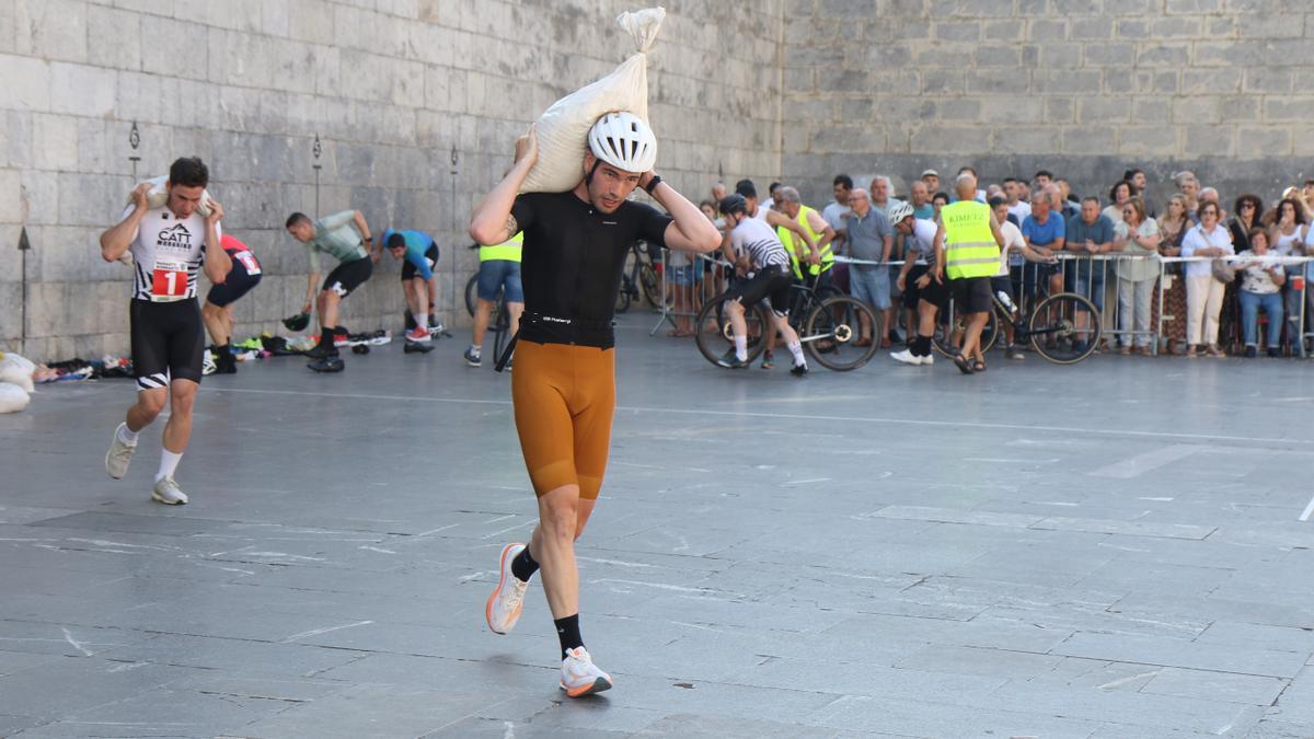 Tras dejar la bicicleta, los participantes deben afrontar un tramo a pie con un saco de arena en la espalda.