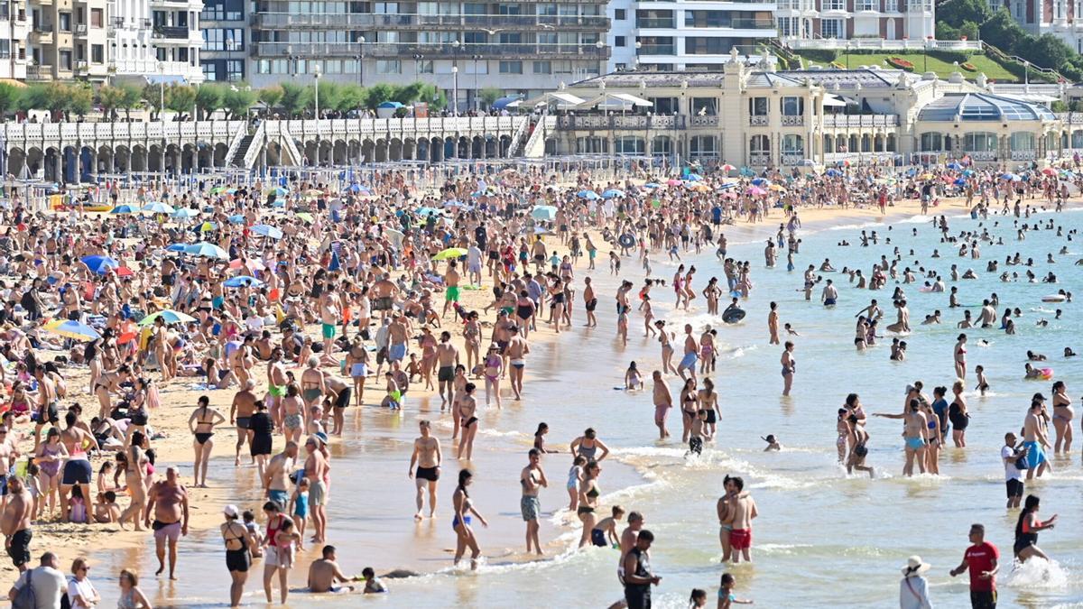 Cientos de personas han acudido este verano a la playa de La Concha, en Donostia, para mitigar el calor.
