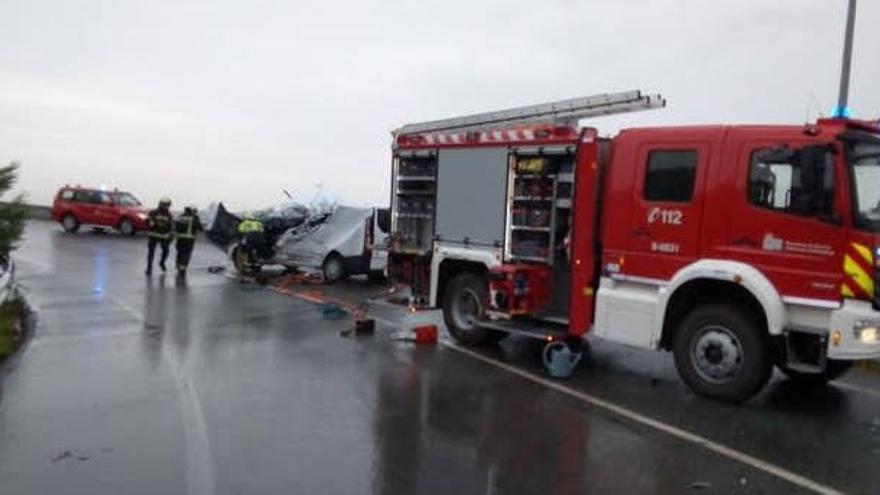 Bomberos junto a la furgoneta accidentada.