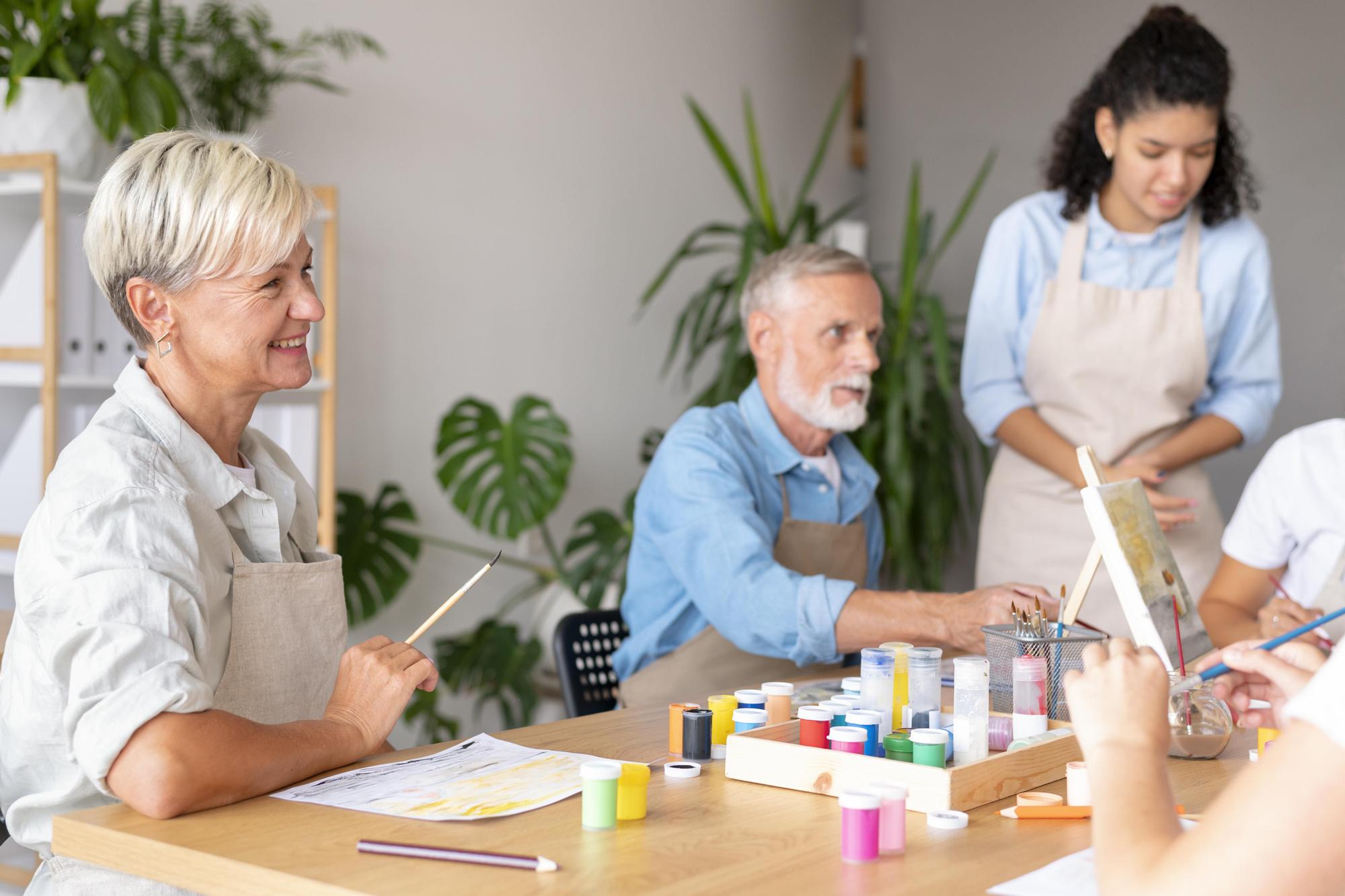 Mujer rubia y hombre con barba acuden a clases de pintura.