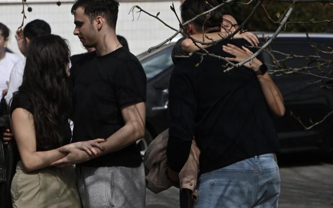 Varias personas, durante el minuto de silencio en homenaje a los estudiantes fallecidos en el derrumbe de una pasarela costera de Santander.