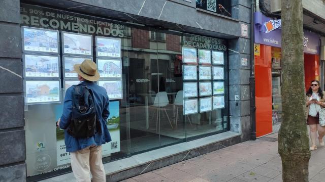 Un hombre mira anuncios de una agencia inmobiliaria