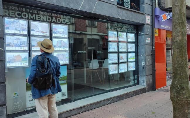 Un hombre mira anuncios de una agencia inmobiliaria
