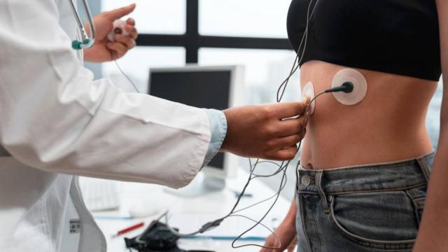 Un doctor prepara a una paciente para realizar una prueba de esfuerzo