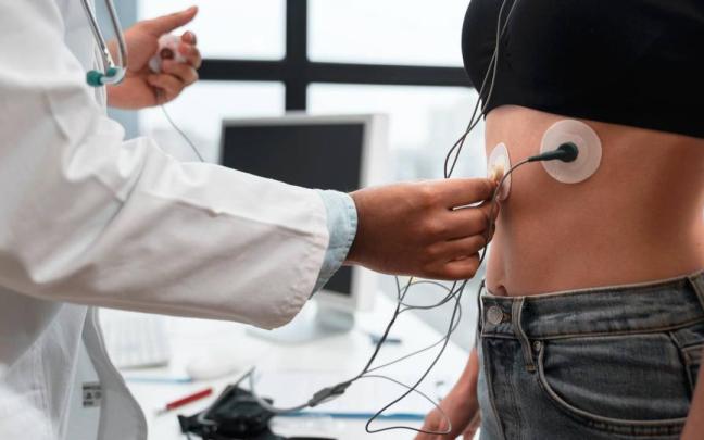 Un doctor prepara a una paciente para realizar una prueba de esfuerzo