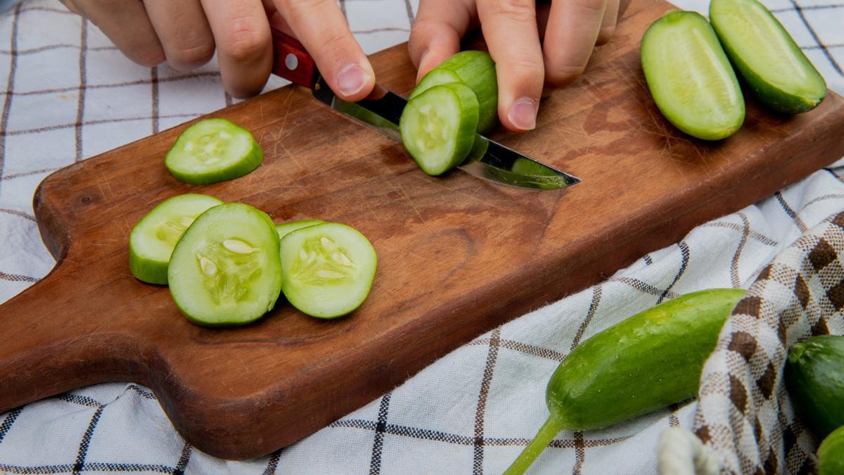 Un cocinero corta un pepino en ruedas gruesas.