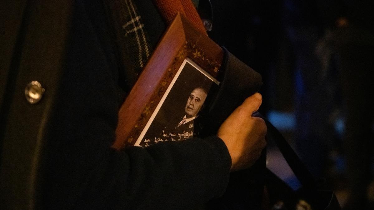 Una persona lleva el retrato de Franco a la salida de la misa en memorial del dictador en el día del 50 aniversario de su muerte, el 20 de noviembre de 2025.