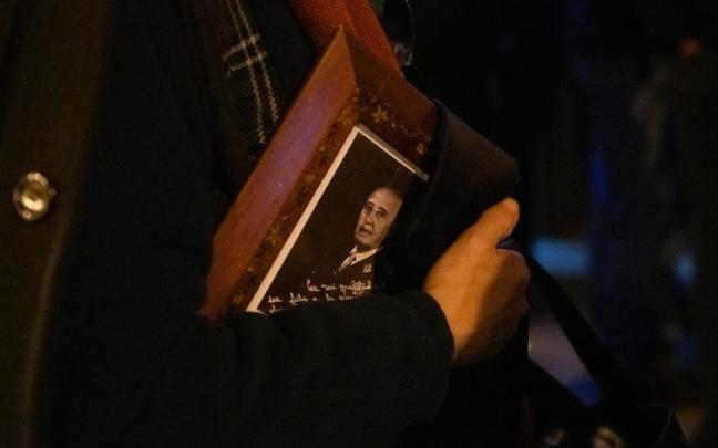 Una persona lleva el retrato de Franco a la salida de la misa en memorial del dictador en el día del 50 aniversario de su muerte, el 20 de noviembre de 2025.