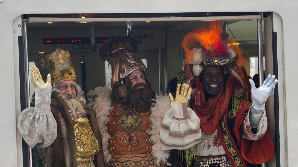 Los tres Reyes Magos saludan tras su llegada en tren.