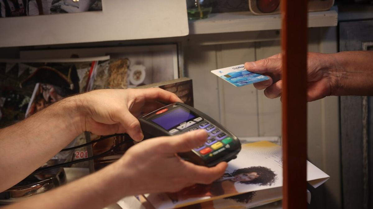 Un hombre, pagando con tarjeta en un comercio.