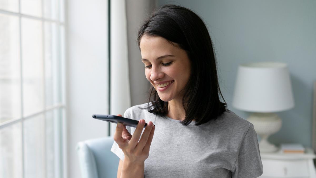 Una mujer graba un mensaje de audio en su teléfono móvil.