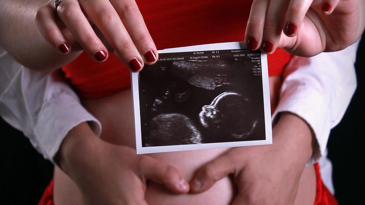 Una mujer muestra una imagen de su bebé.