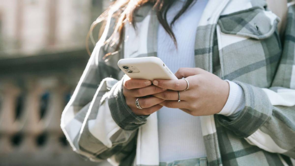 Una joven hace uso del dispositivo móvil.