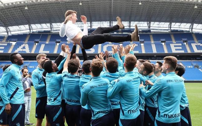 La plantilla txuri-urdin mantea a Illarramendi en su despedida. / N.G.