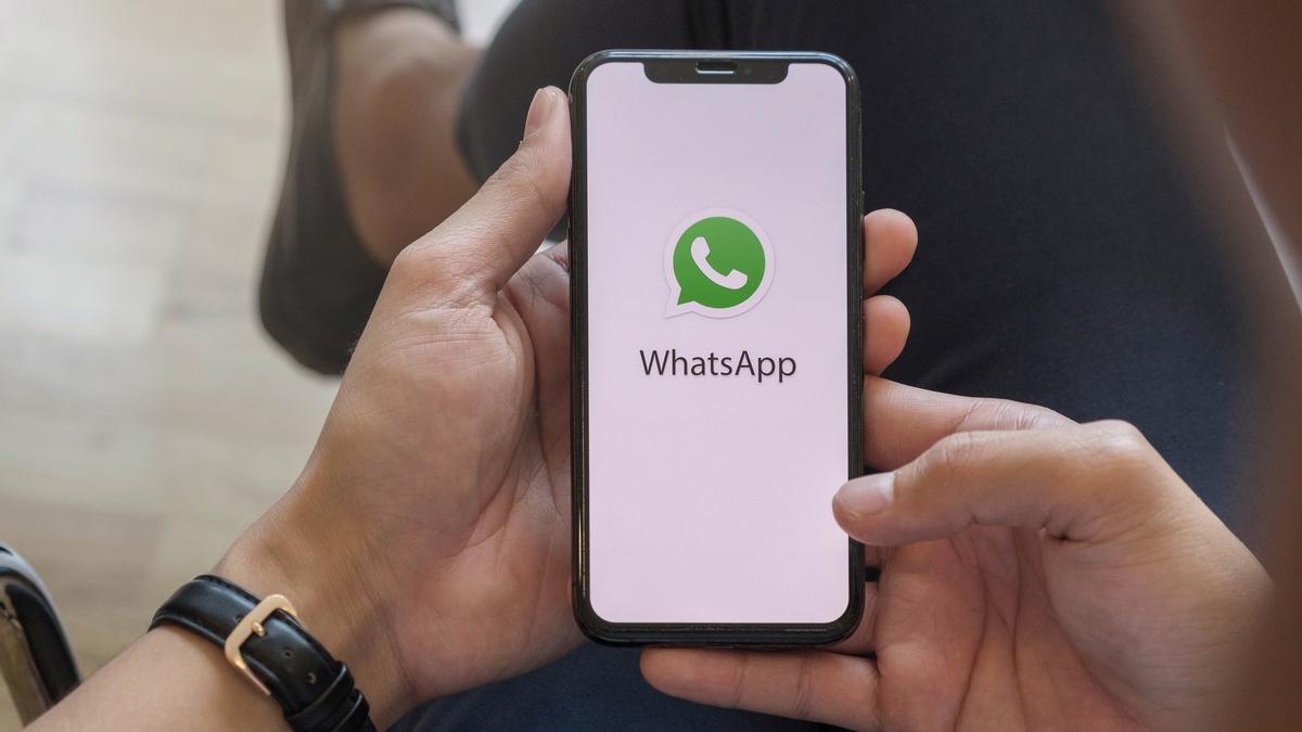 Un hombre sujeta un móvil con el logotipo de la aplicación de WhatsApp.