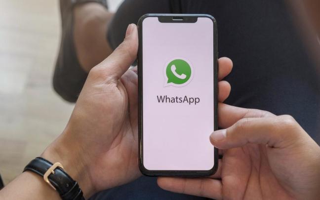 Un hombre sujeta un móvil con el logotipo de la aplicación de WhatsApp. Un hombre sujeta un móvil con el logotipo de la aplicación de WhatsApp.